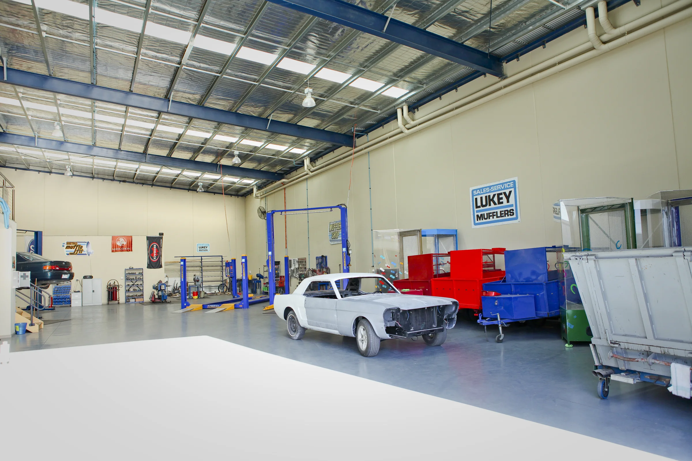 Inside the ATR Automotive workshop, with vehicle hoists and a classic car